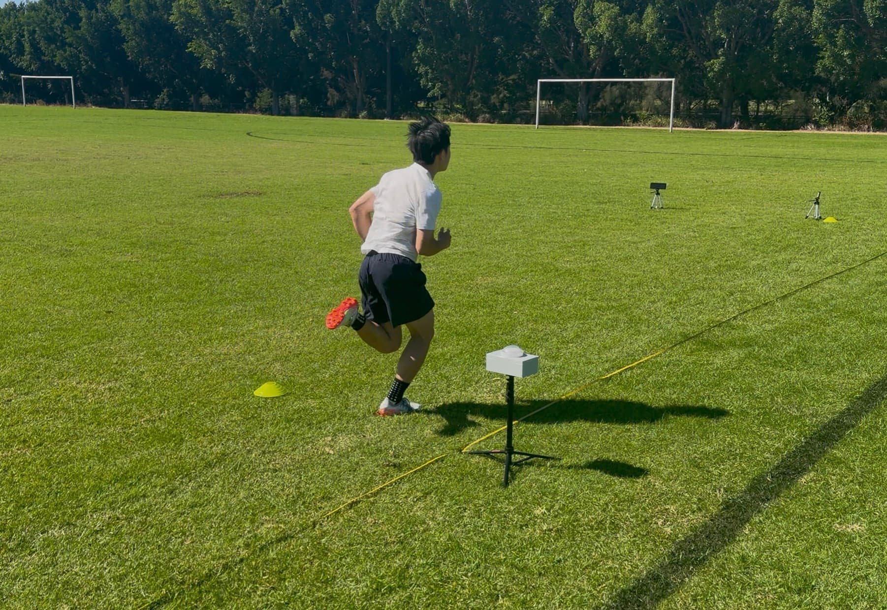 Athlete sprinting through timing gates — the Speed Diagnostic System in action